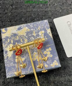 Dior key-shaped earrings with heart pendants on patterned box.