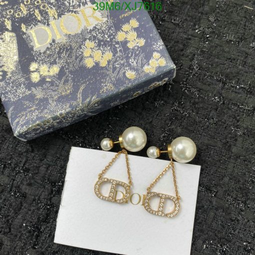 Designer pearl earrings with logo and floral-patterned box.