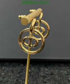 Gold designer logo stick pin on black surface.