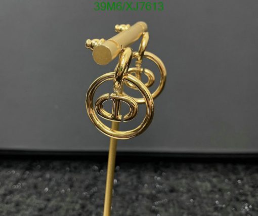 Gold designer logo stick pin on black surface.