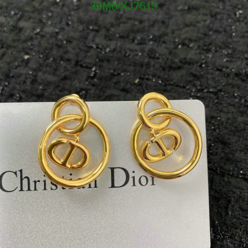 Gold designer logo earrings on branded card.