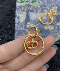 Gold designer logo earrings with box in background.