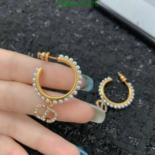 Gold pearl hoop earrings in hand.