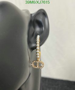 Pearl earring with diamond circle on mannequin ear.