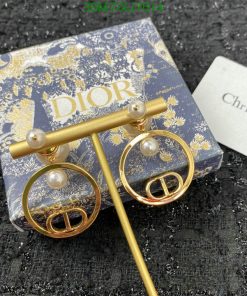 Dior pearl gold earrings on branded packaging.