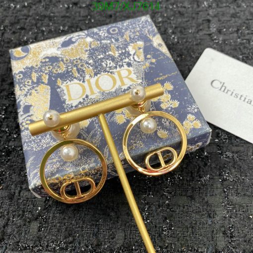 Dior pearl gold earrings on branded packaging.