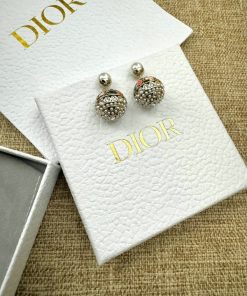 Elegant designer stud earrings on branded packaging.