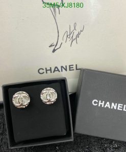 Chanel earrings displayed with box and signature.