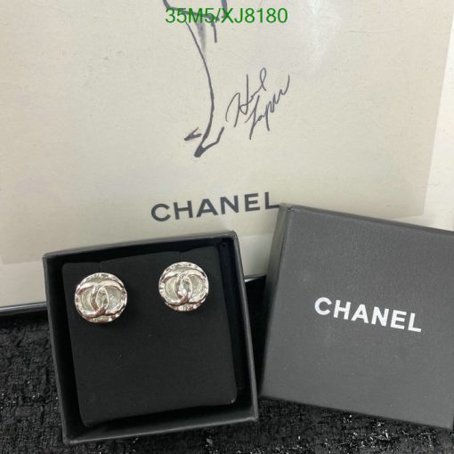 Chanel earrings displayed with box and signature.