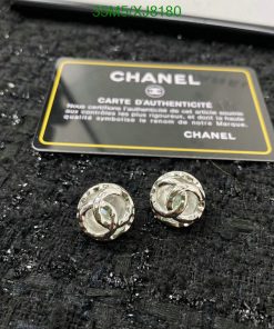 Chanel earrings with authenticity card on black texture.