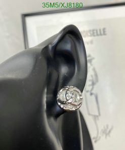 Black mannequin ear displaying silver designer earring.