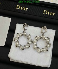 Dior pearl hoop earrings on display with brand packaging.