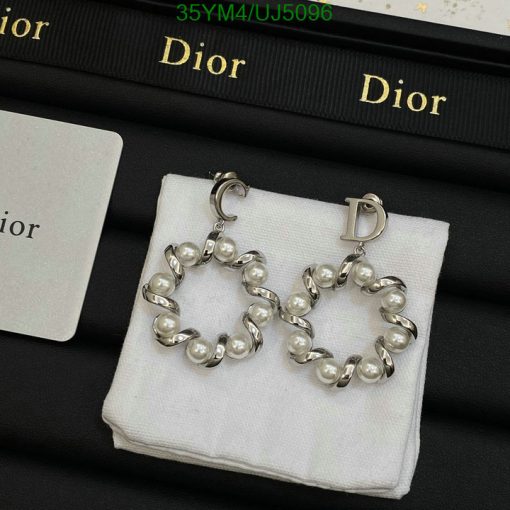 Dior pearl hoop earrings on display with brand packaging.