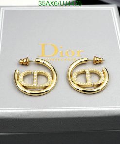 Gold designer logo earrings with crystals on display box.