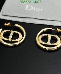 Gold hoop earrings with pearl accents on cloth.