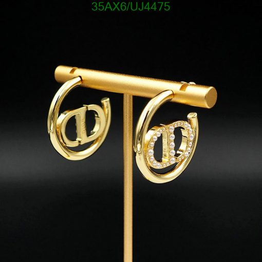 Gold horseshoe earrings with diamonds on black background.