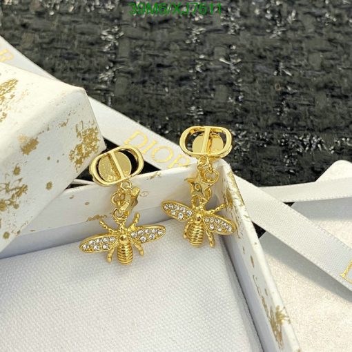 Gold bee-shaped earrings with diamonds on white box.