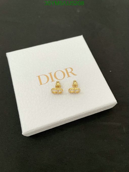 Gold Dior earrings on white display box.