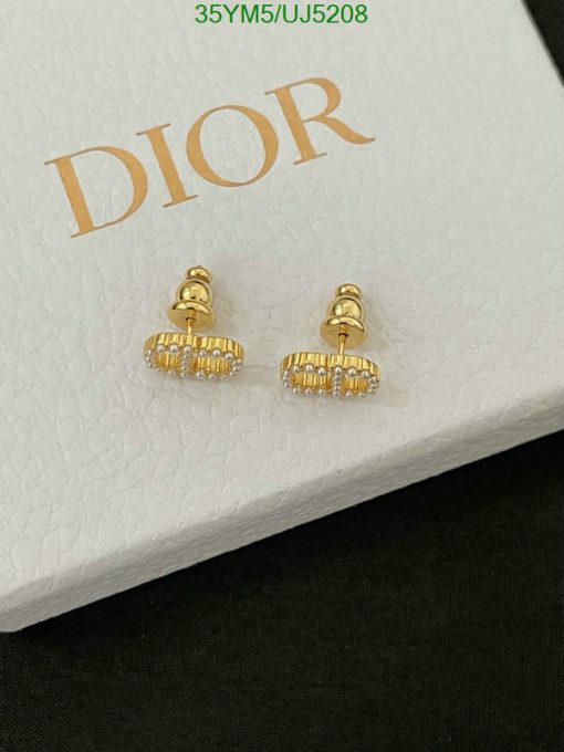 Gold designer logo earrings on branded display box.