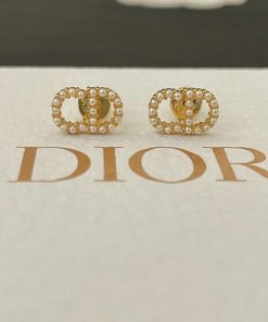 Pearl-embellished gold earrings on branded display card.