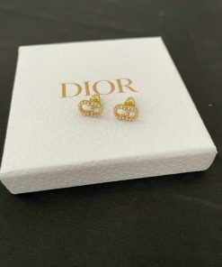 Dior heart-shaped earrings on white display box.