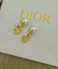 Pearl earrings with gold accents on branded box.