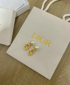 Dior earrings on branded bag with packaging.