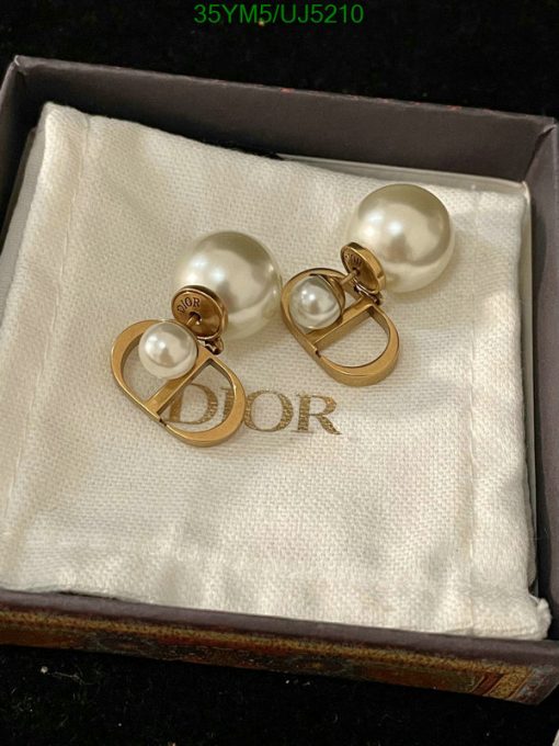 Pearl earrings with gold logo in box.