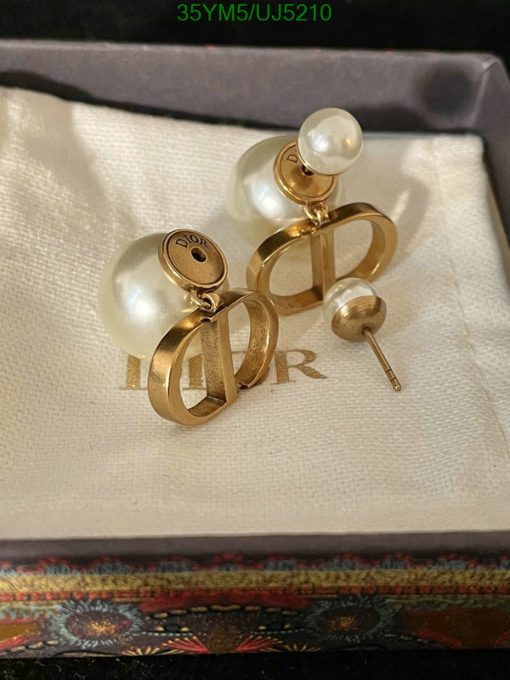 Pearl earrings with gold designer logo in box.