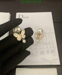 Gold butterfly pearl earrings on display with brand packaging.