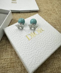 Dior earrings with box on burlap texture surface