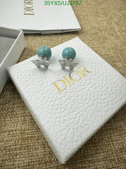 Dior earrings with box on burlap texture surface