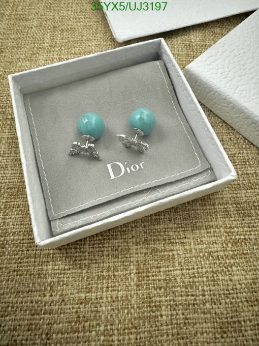 Turquoise earrings in branded box on textured surface.