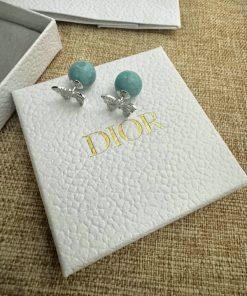 Turquoise bead earrings on white branded display card.