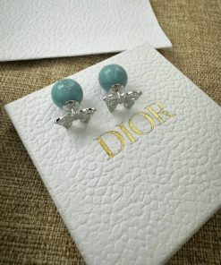 Turquoise Dior earrings on branded card.