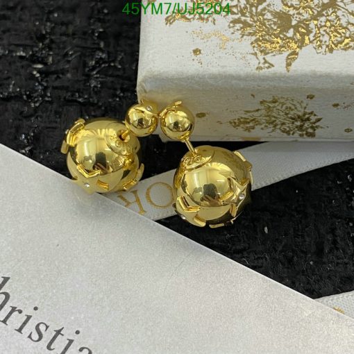 Gold spherical double-drop earrings on textured backdrop.