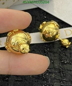 Gold designer spherical stud earrings on display.