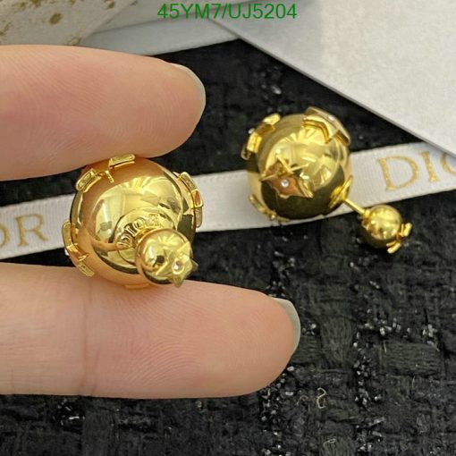 Gold designer spherical stud earrings on display.