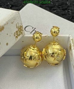 Gold spherical earrings with box on black surface.