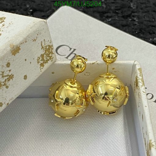 Gold spherical earrings with box on black surface.