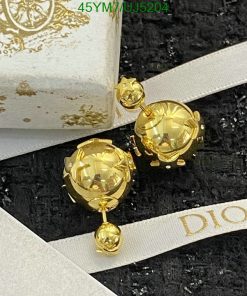 Gold designer dangling earrings on branded packaging.