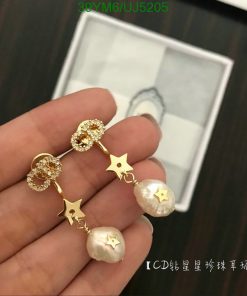 Gold star and pearl drop earrings on display.