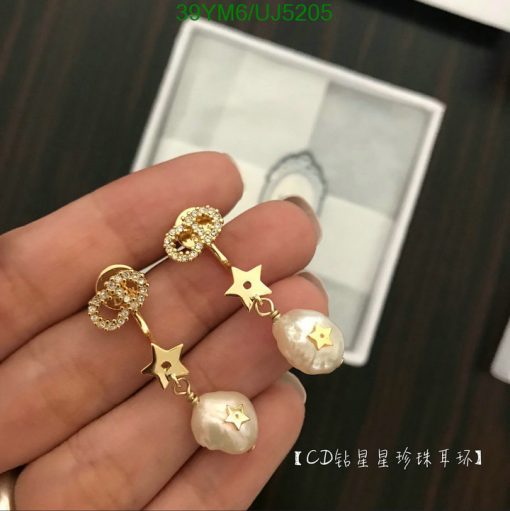 Gold star-shaped earrings with pearls on display.