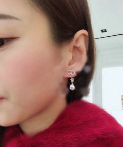 Woman showcasing elegant dangle earrings.