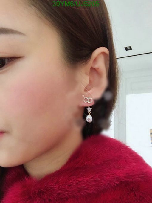 Woman showcasing elegant dangle earrings.