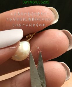 Close-up of pearl earring with Chinese text.