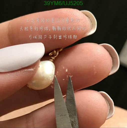 Close-up of pearl earring with Chinese text.