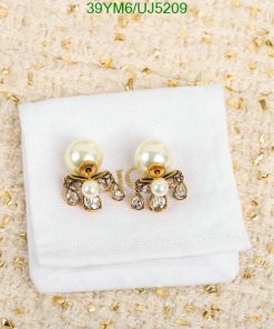 Pearl and crystal bow earrings on cloth.