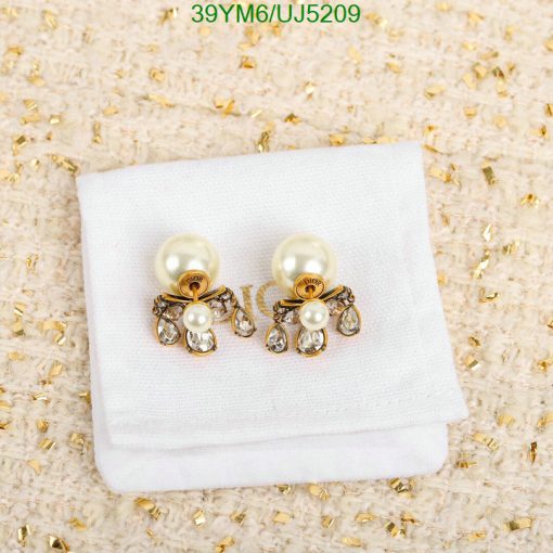 Pearl and crystal bow earrings on cloth.