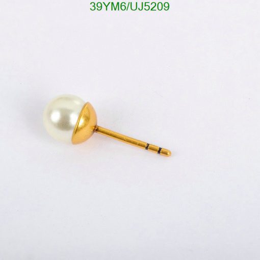 Gold pearl tie tack on white.